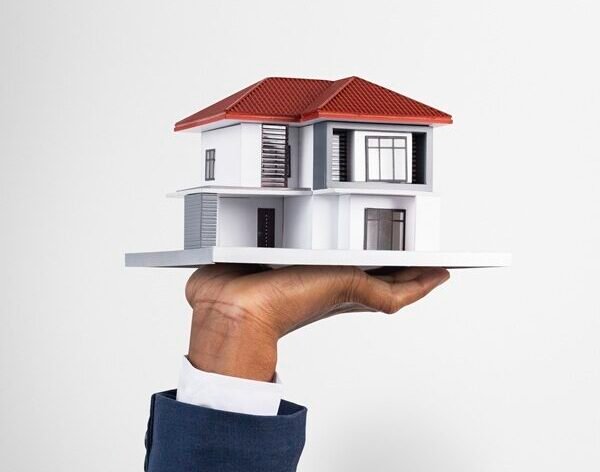 Hand holding house real estate and property model